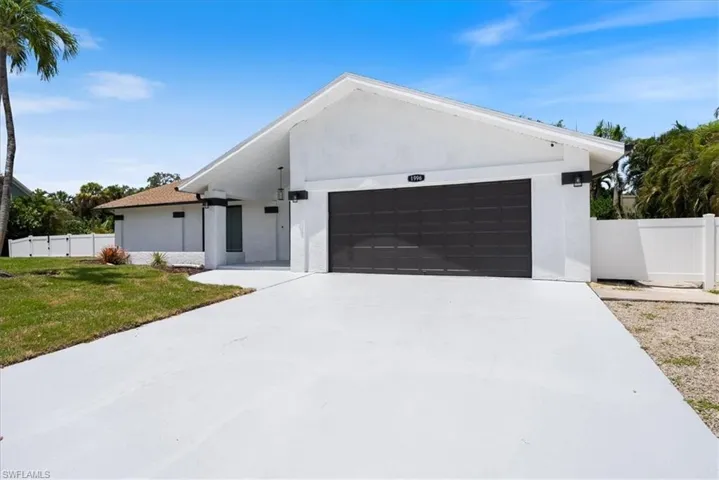 View of front facade featuring an attached garage, stucco siding, and driveway