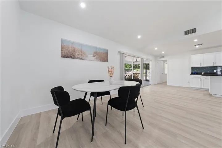 Dining area with recessed lighting and light wood finished floors