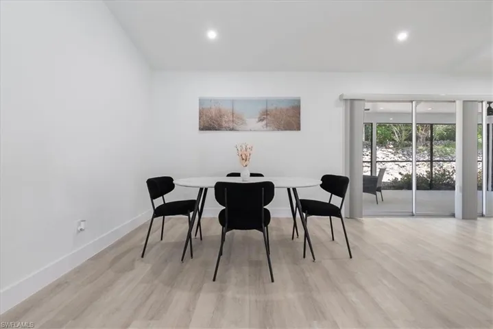 Dining space with light wood-style floors and recessed lighting