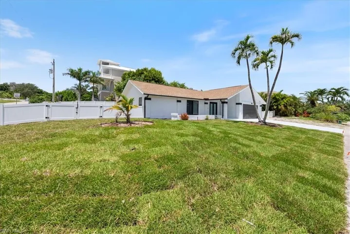 View of front of property featuring concrete driveway, a garage, and a gate
