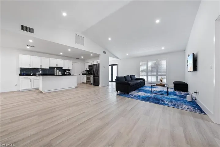 Living room featuring recessed lighting, light wood finished floors, and high vaulted ceiling