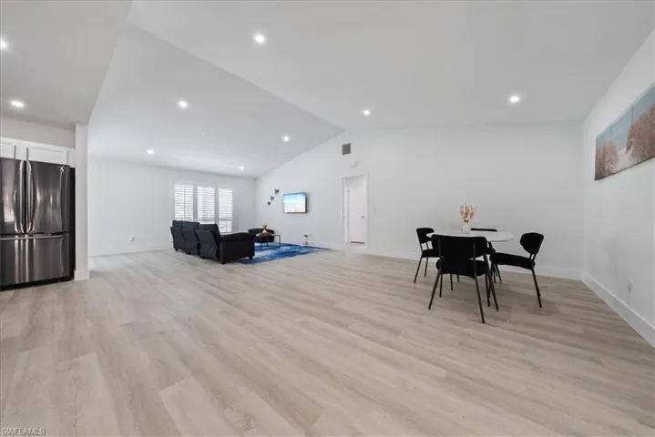 Dining room with vaulted ceiling, recessed lighting, and light wood-style flooring