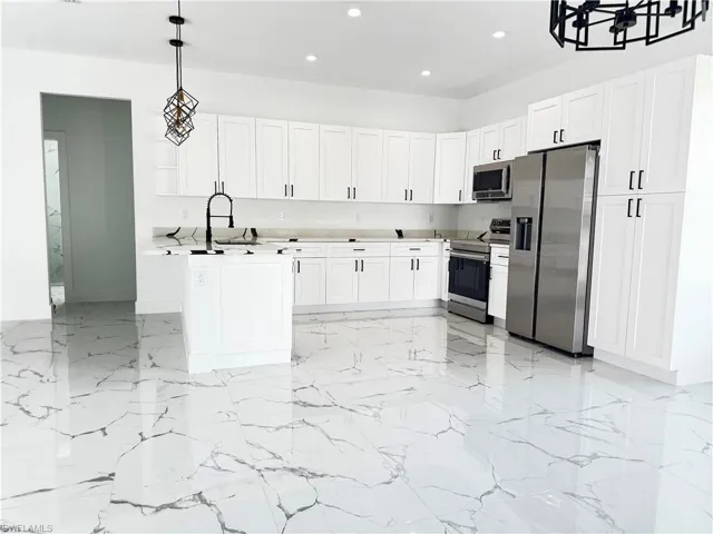 Kitchen with white cabinetry, light countertops, recessed lighting, stainless steel appliances, and pendant lighting