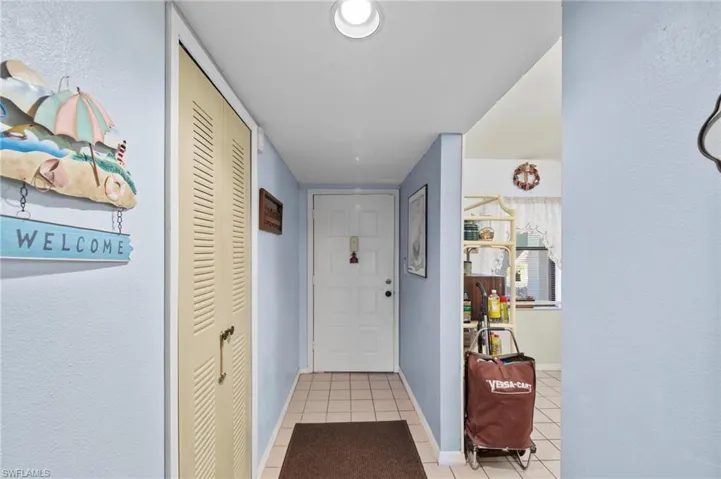 Doorway to outside featuring tile patterned flooring and a textured wall