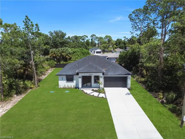 Contemporary single-story home featuring a dark shingle roof and a light-toned exterior