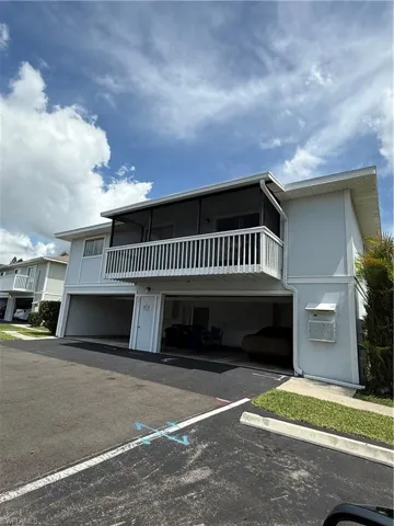 Two-story residential building featuring a screened upper balcony