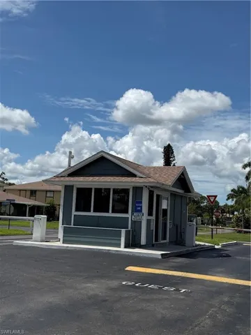 Gatehouse structure featuring a pitched roof, light blue siding, and white trim