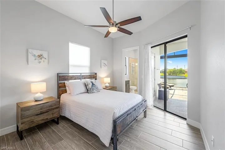 Bedroom with ceiling fan, hardwood / wood-style floors, connected bathroom, and access to outside