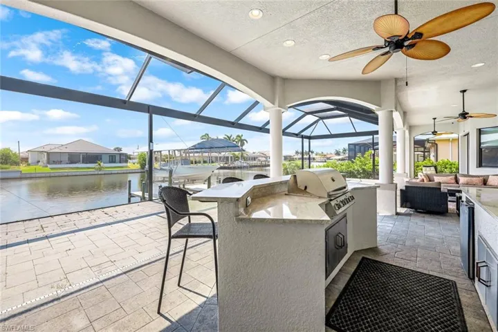 Sunroom / solarium with ceiling fan and a water view