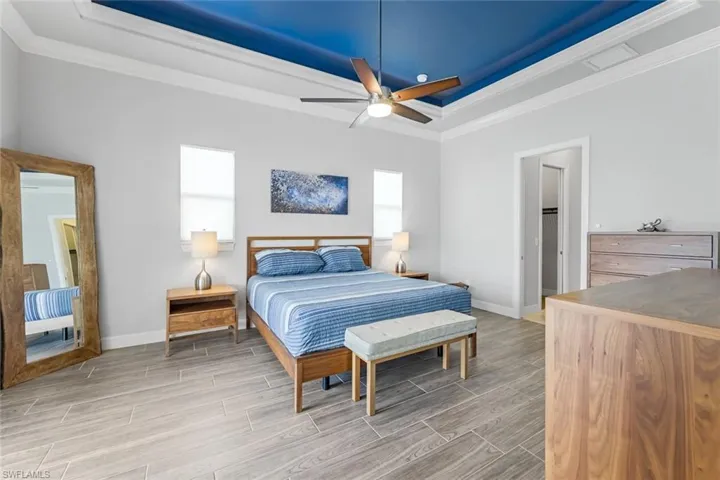 Bedroom with a tray ceiling, crown molding, and ceiling fan