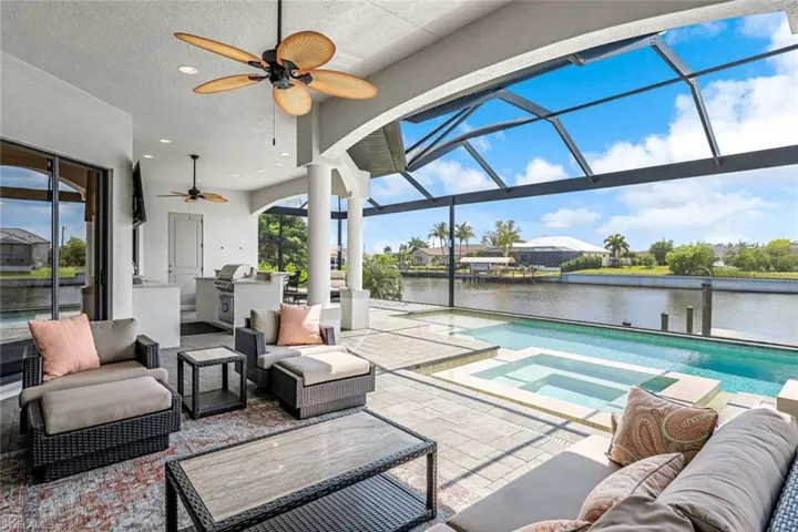 Sunroom / solarium with ceiling fan and a water view
