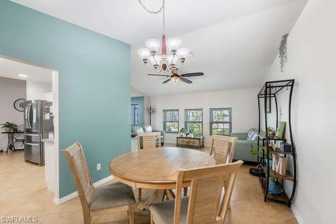 Dining area featuring lofted ceiling and ceiling fan with notable chandelier