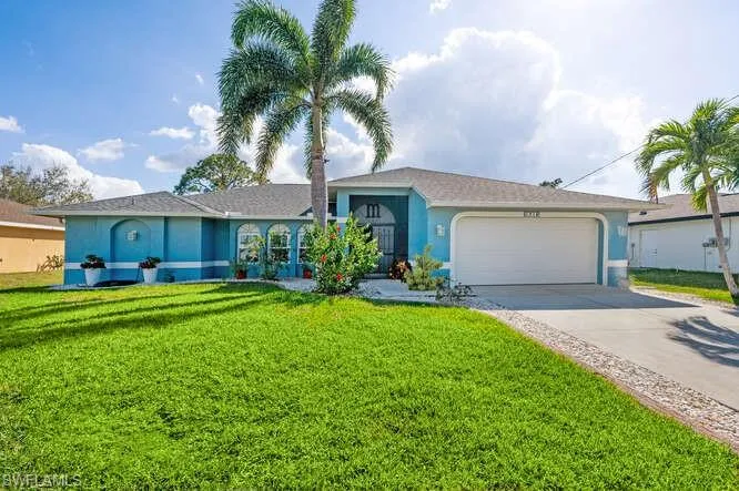 Single story home with a garage and a front lawn