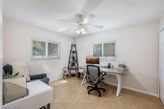 Home office featuring light tile patterned flooring and ceiling fan