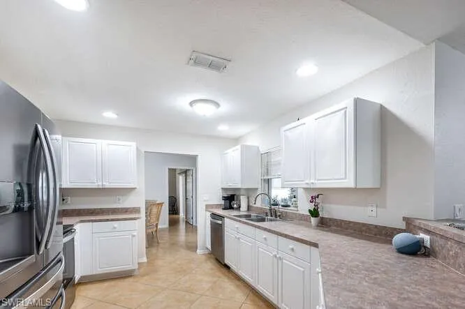 Kitchen featuring white cabinetry, appliances with stainless steel finishes, and sink