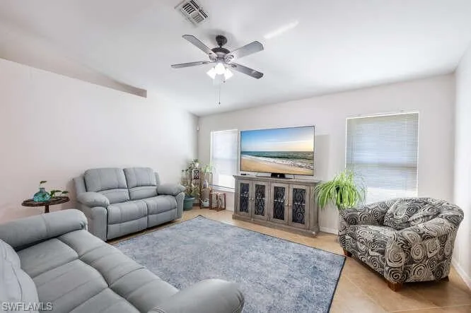 Living room with light tile patterned floors and ceiling fan