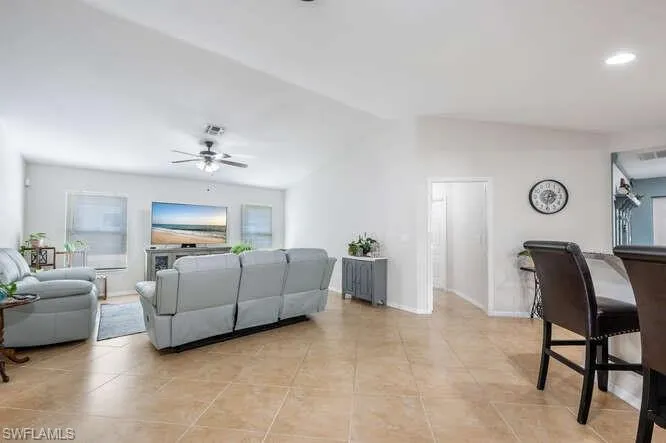 Tiled living room featuring vaulted ceiling and ceiling fan