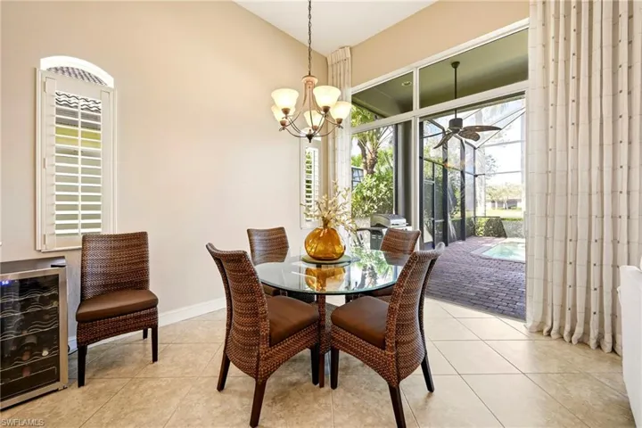 Dining room featuring wine cooler, light tile patterned floors, ceiling fan, and suspended lighting