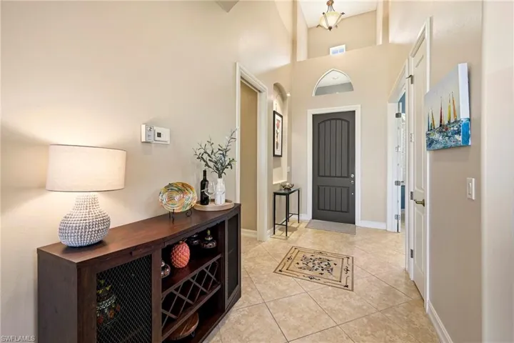Foyer with light tile patterned floors, a high ceiling, and arched walkways