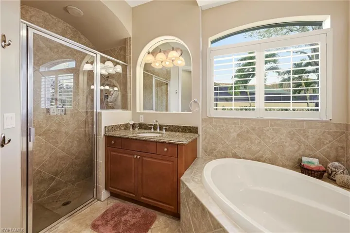 Bathroom featuring a shower stall, vanity, and a bath