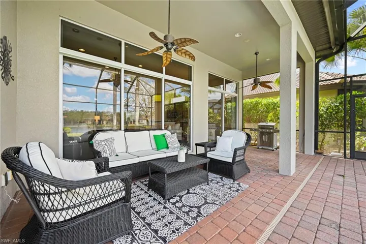 View of patio / terrace featuring glass enclosure, an outdoor living space, a ceiling fan, and area for grilling