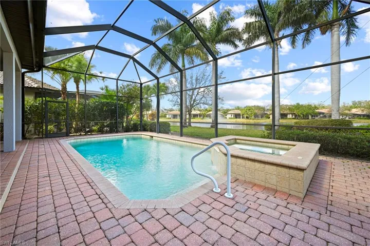 Swimming pool with a patio area, a lanai, a sunroom, and an outdoor hot tub