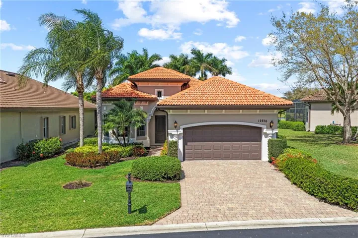 Mediterranean / spanish-style home featuring a front yard, stucco siding, an attached garage, a tiled roof, and decorative driveway