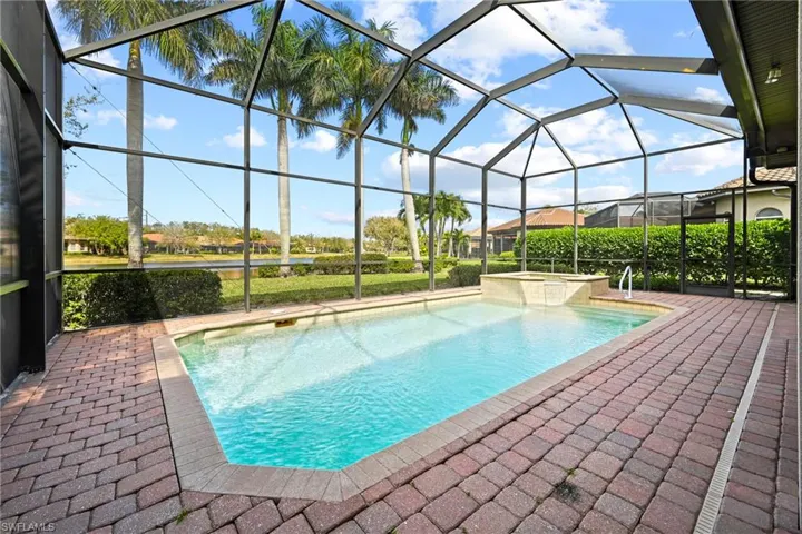 Integrated pool / hot tub with a sunroom, a patio, and a lanai