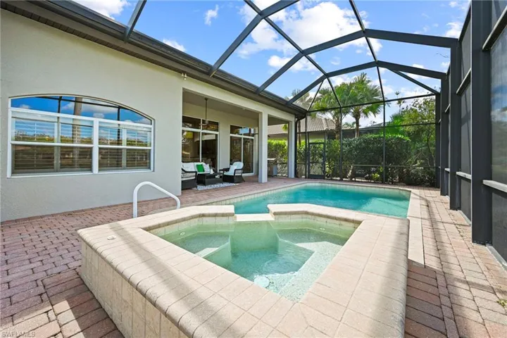 Integrated pool / hot tub with a patio, a sunroom, a lanai, and an outdoor living space