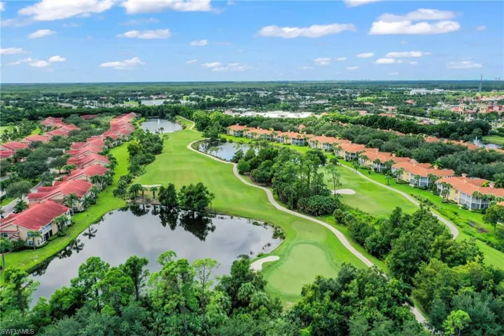 Drone / aerial view of a golf course and a nearby body of water