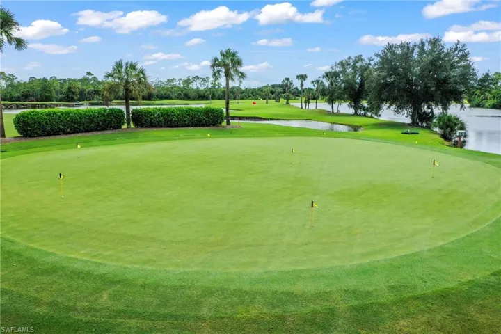 Surrounding community with golf course view, a water view, view of wooded area, and a putting area