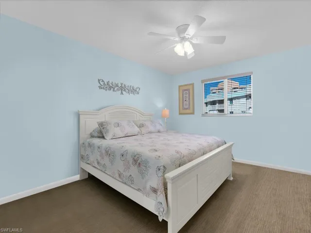 Carpeted bedroom featuring baseboards and ceiling fan