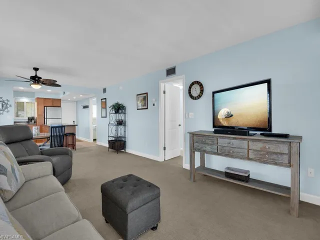 Carpeted living area with baseboards and a ceiling fan