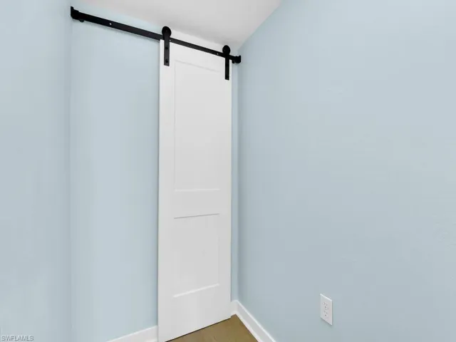 Empty room with a barn door and wood finished floors