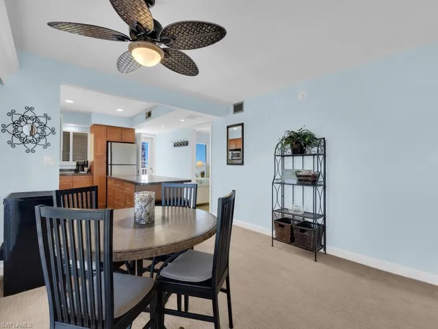 Dining area with light carpet, a ceiling fan, and recessed lighting
