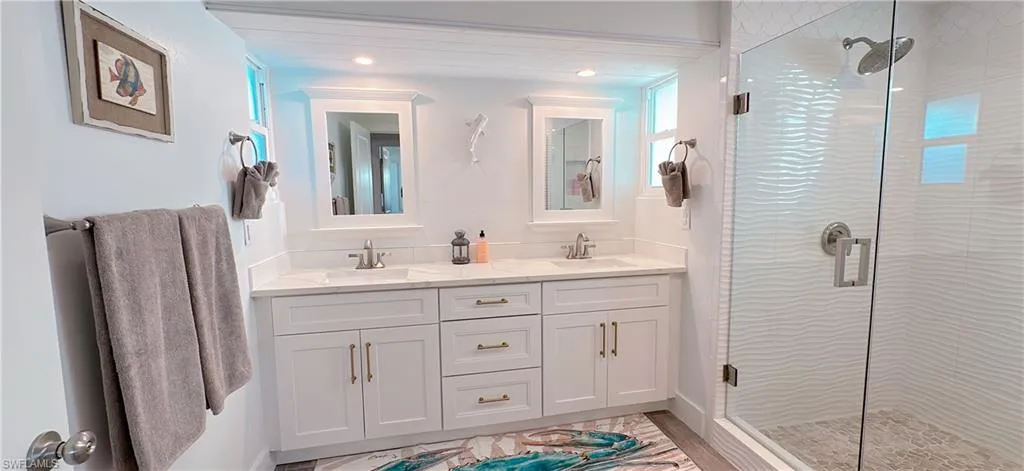 Dual vanity featuring white shaker cabinetry, quartz countertops, and undermount sinks