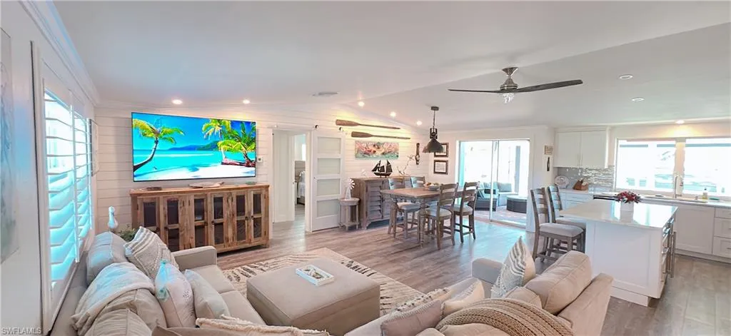 Open-concept living space featuring wood-finish flooring, recessed lighting, and a ceiling fan