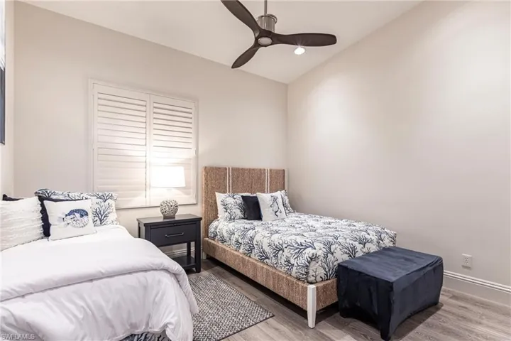 Bedroom featuring recessed lighting, a ceiling fan, vaulted ceiling, baseboards, and wood finished floors