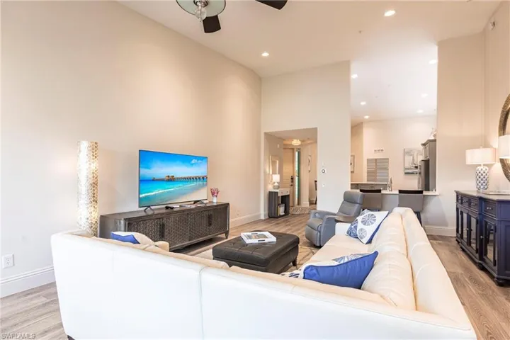 Living area featuring light wood-style floors, a ceiling fan, recessed lighting, and baseboards