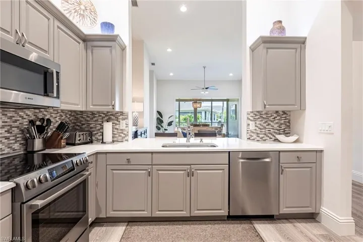 Kitchen with gray cabinets, stainless steel appliances, ceiling fan, and a sink