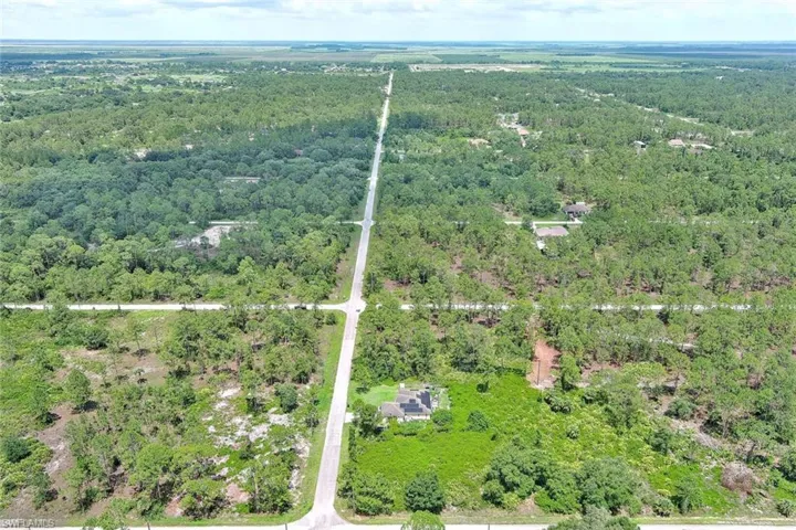 Aerial view of property and surrounding area featuring a heavily wooded area