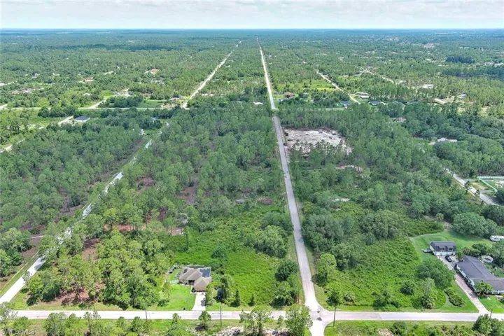 Aerial overview of property's location with a heavily wooded area
