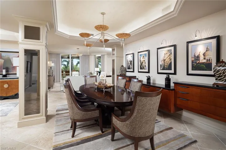 Dining space with a raised ceiling and crown molding