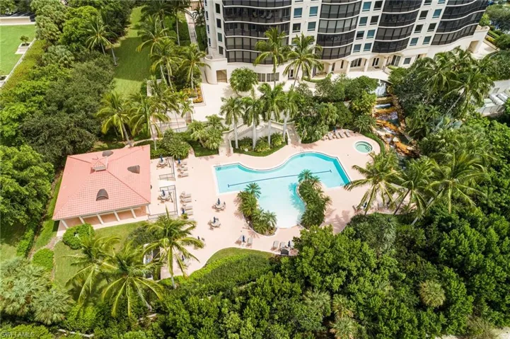 Drone / aerial view of a pool area and apartment complex