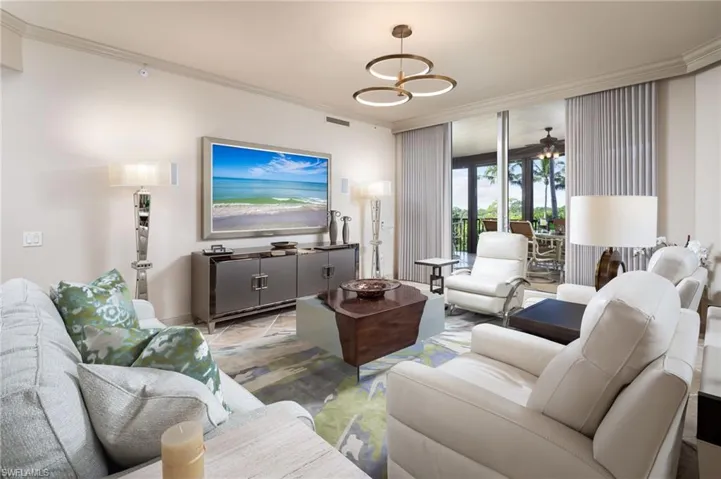Living room with crown molding and ceiling fan