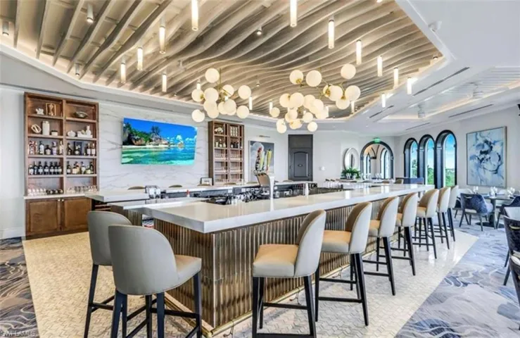Bar with light stone counters and open shelves