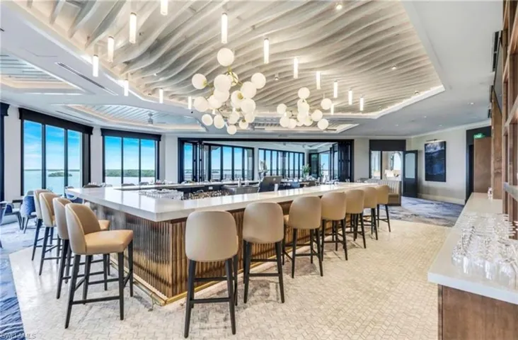 Bar area featuring light stone countertops and a wall of windows