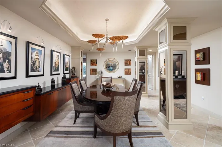 Dining area featuring a tray ceiling and a chandelier