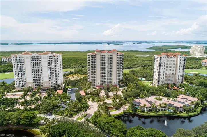 Drone / aerial view of apartment complex and a large body of water