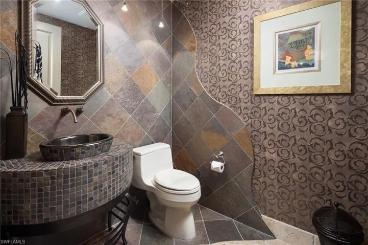 Bathroom featuring a sink and tile walls